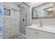 Modern bathroom featuring a stand-up shower with white subway tiles, pebble floor, and a large vanity sink at 2172 Se Wakita Se Dr, Marietta, GA 30060