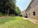 A large backyard has a patio, privacy trees, and lawn at 3389 Rosecliff Trce, Buford, GA 30519
