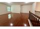 Bright living room featuring hardwood floors and a staircase with dark wood banister at 3389 Rosecliff Trce, Buford, GA 30519