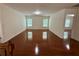 Spacious living room with hardwood floors, neutral walls, and plenty of natural light from two large windows at 3389 Rosecliff Trce, Buford, GA 30519