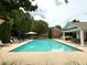 Community pool area with lounge chairs and tables surrounded by trees at 3389 Rosecliff Trce, Buford, GA 30519