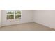 Empty bedroom with neutral-toned carpet, a large window for natural light, and white walls at 625 Kimberwick Dr, Locust Grove, GA 30248