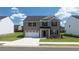 Charming two-story home with gray brick, black shutters, attached two-car garage and a well-manicured lawn at 625 Kimberwick Dr, Locust Grove, GA 30248