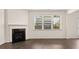 Cozy living room with a fireplace, large window, and beautiful hardwood floors at 625 Kimberwick Dr, Locust Grove, GA 30248