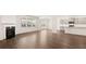 Open-concept living room featuring a fireplace, hardwood floors, and large windows, leading to a modern kitchen at 625 Kimberwick Dr, Locust Grove, GA 30248