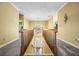 Well-lit upstairs hallway overlooking the front entrance with decorative window, carpeted floor, and wood railing at 2610 Chadwick Rd, Marietta, GA 30066