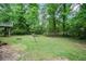 View of backyard showing fire pit, lush green grass, and surrounding trees at 3006 Alberta Dr, Marietta, GA 30062