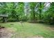Lush backyard with a firepit area and a view of the elevated deck, surrounded by mature trees at 3006 Alberta Dr, Marietta, GA 30062
