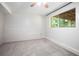Finished basement bedroom with large window and carpet floors; view of trees outside the window at 3006 Alberta Dr, Marietta, GA 30062