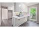 Bright kitchen with white cabinets, gray vinyl floors, a peninsula and a window overlooking the backyard at 3006 Alberta Dr, Marietta, GA 30062