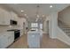 Bright open kitchen boasts an island with sink, stainless appliances, and stylish pendant lighting at 3338 Cranston Ln, Kennesaw, GA 30144