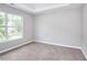 Carpeted bedroom featuring a window, and a tray ceiling in a neutral color scheme at 4041 Ash Tree St, Snellville, GA 30039