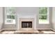 Cozy fireplace with white mantel is flanked by bright, natural-light-filled windows at 4041 Ash Tree St, Snellville, GA 30039