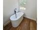 Bathroom featuring a modern soaking tub with black faucet and window view at 681 Burtons Cv, Hampton, GA 30228