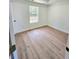 Bedroom with a large window, wood-look flooring and a neutral color palette at 681 Burtons Cv, Hampton, GA 30228