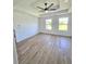 Spacious bedroom with a tray ceiling, ceiling fan, wood-look floors and two windows at 681 Burtons Cv, Hampton, GA 30228