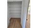 Spacious walk-in closet with ample shelving and wood flooring at 681 Burtons Cv, Hampton, GA 30228