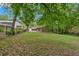 Large grassy backyard with mature trees and greenery, and a wooden fence line at 124 Chaseland Rd, Atlanta, GA 30328