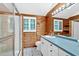 Rustic bathroom with wood paneling, white vanity, shower with glass door, and modern fixtures at 124 Chaseland Rd, Atlanta, GA 30328