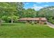 Charming single-story home with a well-manicured front lawn and lush landscaping at 124 Chaseland Rd, Atlanta, GA 30328