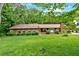 Charming single-story home with a well-manicured front lawn and lush landscaping at 124 Chaseland Rd, Atlanta, GA 30328