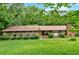Charming ranch-style home with a brick facade, well-maintained lawn, and mature trees offering plenty of shade at 124 Chaseland Rd, Atlanta, GA 30328