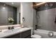 Modern bathroom with gray tile, a bathtub, and a vanity with an illuminated mirror at 145 Silver Mine Trl, Austell, GA 30168