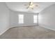 Spacious carpeted bedroom with two large windows and ceiling fan at 145 Silver Mine Trl, Austell, GA 30168