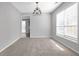 Sunny dining room with modern chandelier, carpet, and large windows offering ample natural light at 145 Silver Mine Trl, Austell, GA 30168