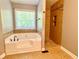 Bright bathroom featuring a large tub beneath a window and a walk-in shower with mosaic tiles at 148 Paradise Xing, Douglasville, GA 30134