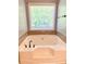 Close up of bathroom tub with tile accents and a large window at 148 Paradise Xing, Douglasville, GA 30134