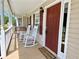 Inviting covered front porch with rocking chairs, porch swing, and a welcoming welcome mat at 148 Paradise Xing, Douglasville, GA 30134