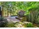 Beautiful backyard patio featuring lush landscaping and a brick retaining wall with stairs at 265 Tara Trl, Atlanta, GA 30327