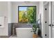 Bright bathroom showcasing a soaking tub with a large window and elegant neutral decor at 265 Tara Trl, Atlanta, GA 30327
