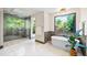 Bright bathroom with a soaking tub and a large picture window overlooking lush greenery at 265 Tara Trl, Atlanta, GA 30327