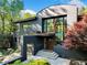 Striking modern home featuring a unique curved roofline and expansive windows, surrounded by lush greenery at 265 Tara Trl, Atlanta, GA 30327