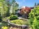 Contemporary home showcasing a well-manicured lawn, stone landscaping, and mature trees, offering a serene setting at 265 Tara Trl, Atlanta, GA 30327