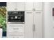 Modern kitchen with white cabinets, a built-in coffee machine, and stainless steel hardware at 265 Tara Trl, Atlanta, GA 30327