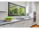 Modern kitchen sink with stone countertops, new appliances, and a bright window view at 265 Tara Trl, Atlanta, GA 30327