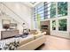 Elegant living room boasting high ceilings, a fireplace, large windows, hardwood floors, and chic furnishings at 265 Tara Trl, Atlanta, GA 30327