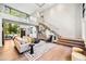 Open-concept living space featuring a staircase with glass railings, large windows, and stylish contemporary furniture at 265 Tara Trl, Atlanta, GA 30327