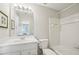 Bathroom with white vanity, framed art, a large mirror, and a combined tub and shower with white tile at 2871 Trailing Ivy Way, Buford, GA 30519