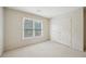 Simple bedroom features neutral walls, large window for natural light, and carpet flooring at 2871 Trailing Ivy Way, Buford, GA 30519