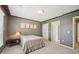 Cozy bedroom with a brick accent wall and a window, with wall art, carpet and a ceiling light at 2871 Trailing Ivy Way, Buford, GA 30519