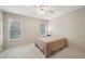 Bright bedroom featuring two windows, neutral-toned walls, a ceiling fan, and neutral carpet flooring at 2871 Trailing Ivy Way, Buford, GA 30519