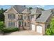 Charming brick two-story home with a well-manicured lawn and attached two-car garage at 2871 Trailing Ivy Way, Buford, GA 30519