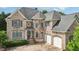 Charming brick home featuring a manicured lawn, multiple windows, and an attached two-car garage at 2871 Trailing Ivy Way, Buford, GA 30519
