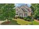 Beautiful home exterior showcasing lush landscaping, mature trees, and well-maintained lawn at 2871 Trailing Ivy Way, Buford, GA 30519