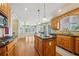 Spacious kitchen with wood cabinets, an island with black countertop, and pendant lighting at 2871 Trailing Ivy Way, Buford, GA 30519
