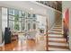 Spacious living room featuring large windows, hardwood floors, fireplace, and elegant staircase at 2871 Trailing Ivy Way, Buford, GA 30519